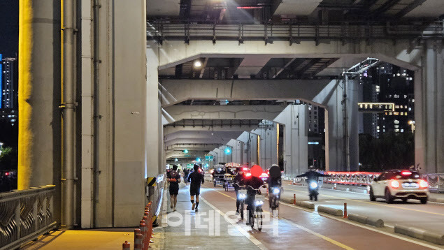 지난 8일 저녁 서울 서초구 반포동의 잠수교에서 달리는 사람들 옆으로 자전거를 탄 사람들이 지나가고 있다(사진=김세연기자)