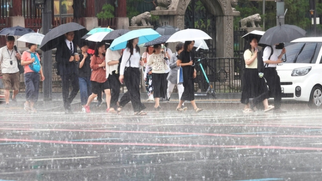 서울 광화문거리에서 우산 쓴 시민들이 발걸음을 재촉하고 있다. [이충우 기자]