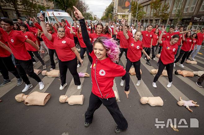 [부쿠레슈티=AP/뉴시스] 16일(현지시각) 루마니아 부쿠레슈티에서 세계 심폐소생의 날을 기념하는 플래시몹이 열려 루마니아 적십자 대원들이 심폐소생술(CPR) 음악에 맞춰 춤추고 있다.  10월 16일은 '세계 심폐소생의 날'로 응급상황을 대비해 많은 사람이 CPR을 배울 수 있게 교육해야 한다는 취지로 제정됐다. 미국심장협회는 그룹 '비지스'의 히트곡 '스테잉 얼라이브'를 CPR 시행 시 리듬 맞추기 좋은 노래로 선정한 바 있다. 2024.10.17.