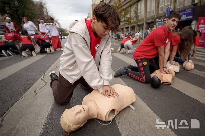 [부쿠레슈티=AP/뉴시스] 16일(현지시각) 루마니아 부쿠레슈티에서 세계 심폐소생의 날을 기념하는 플래시몹이 열려 루마니아 적십자 대원들이 마네킹을 이용해 심폐소생술(CPR)을 하고 있다.  10월 16일은 '세계 심폐소생의 날'로 응급상황을 대비해 많은 사람이 CPR을 배울 수 있게 교육해야 한다는 취지로 제정됐다. 미국심장협회는 그룹 '비지스'의 히트곡 '스테잉 얼라이브'를 CPR 시행 시 리듬 맞추기 좋은 노래로 선정한 바 있다. 2024.10.17.