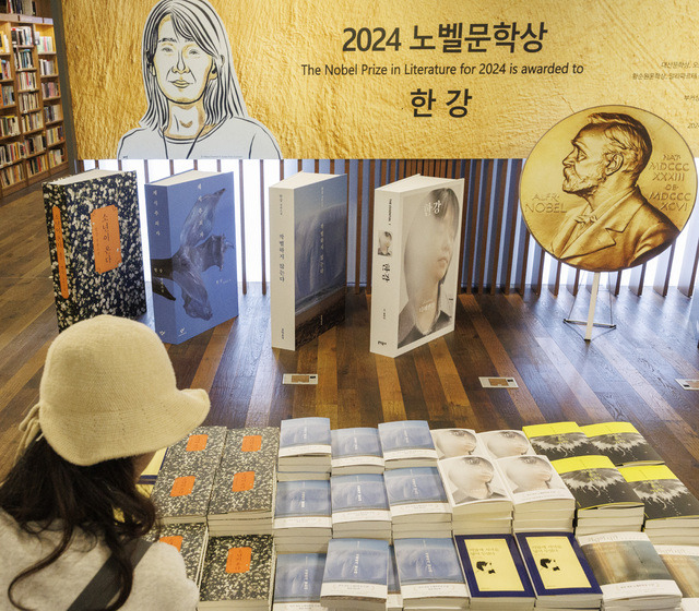 16일 서울 종로구 교보문고 광화문점을 찾은 시민이 노벨문학상을 수상한 한강의 작품들을 고르고 있다. 연합뉴스