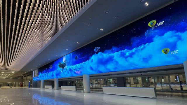 17일 공개된 인천국제공항 제2여객터미널 확장부 입국장 안내판. 폭이 60m에 달하는 화면 오른쪽(동쪽)에서 중앙의 공중섬(영종도)로 접근하는 열기구들이 보인다. 열기구는 비행기를 표현한 것으로 도착 시간과 항공기 명칭이 함께 표기된다. 화면 양끝에는 전통적 안내판도 함께 표시된다. 김민호 기자