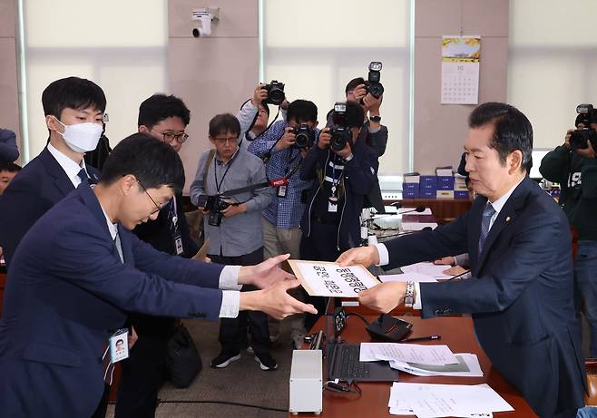 정청래 법사위원장(오른쪽)이 21일 서울 여의도 국회에서 열린 법제사법위원회의 대검찰청 대상 국정감사에서 김건희 여사 동행명령장을 발부, 국회 사무처 직원들에게 전달하고 있다. /연합뉴스