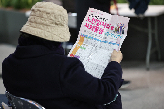 한 시민이 서울 마포구청에서 열린 노인 일자리 박람회에서 안내문을 읽고 있다.   [연합뉴스]