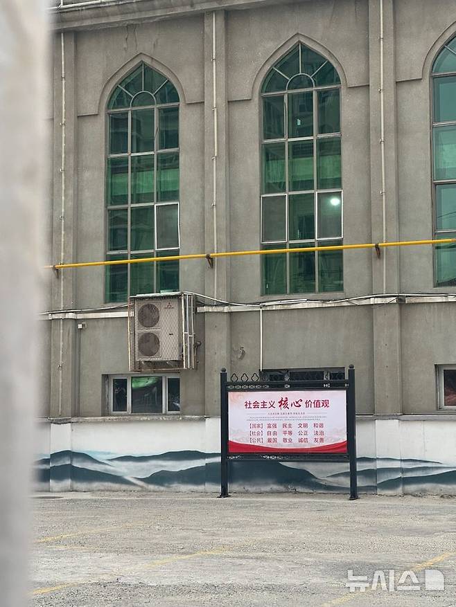 [우루무치=뉴시스] 문예성 기자= 17일 중국 신장위구르자치구 우루무치시의 양항모스크 마당에 '사회주의 핵심 가치관'이 적힌 팻말이 세워져 있다. 2024.10.20 sophis731@newsis.com