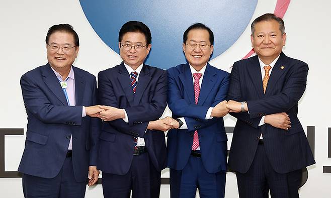 우동기(왼쪽부터) 지방시대위원장, 이철우 경북도지사, 홍준표 대구시장, 이상민 행정안전부 장관이 21일 서울 종로구 정부서울청사에서 열린 대구·경북 통합 관련 4자 회동에서 합의문에 서명한 뒤 기념촬영을 하고 있다. 연합뉴스