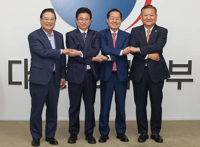 21일 오후 서울 종로구 정부서울청사에서 우동기(왼쪽부터) 지방시대위원회 위원장과 이철우 경북도지사, 홍준표 대구시장, 이상민 행정안전부 장관이 대구·경북 통합을 위한 공동 합의문에 서명한 뒤 손을 맞잡고 있다. /장련성 기자