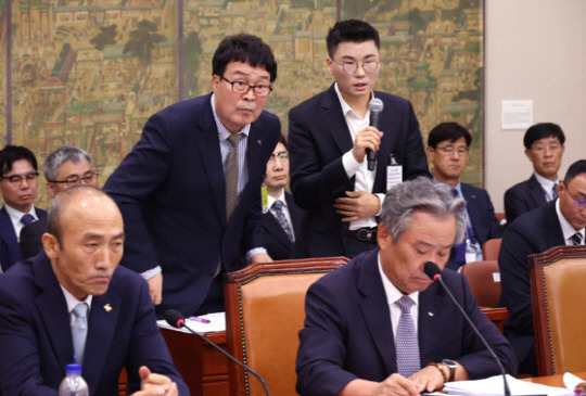 22일 국회에서 열린 문화체육관광위원회 국정감사에서 김택규 대한배드민턴협회장(왼쪽)과 민경국 스포츠에이전시 대표가 안세영 선수와 관련 의원 질의에 답하고 있다. 연합뉴스