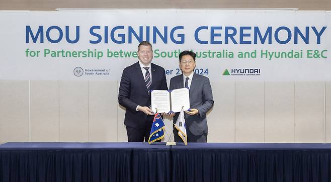 Choi Young (right), head of the new energy division of Hyundai E&C, and Joe Szakacs, South Australian Minister of Trade and Investment pose for a photo during a memorandum of understanding signing ceremony in Seoul on Monday. (Hyundai E&C)