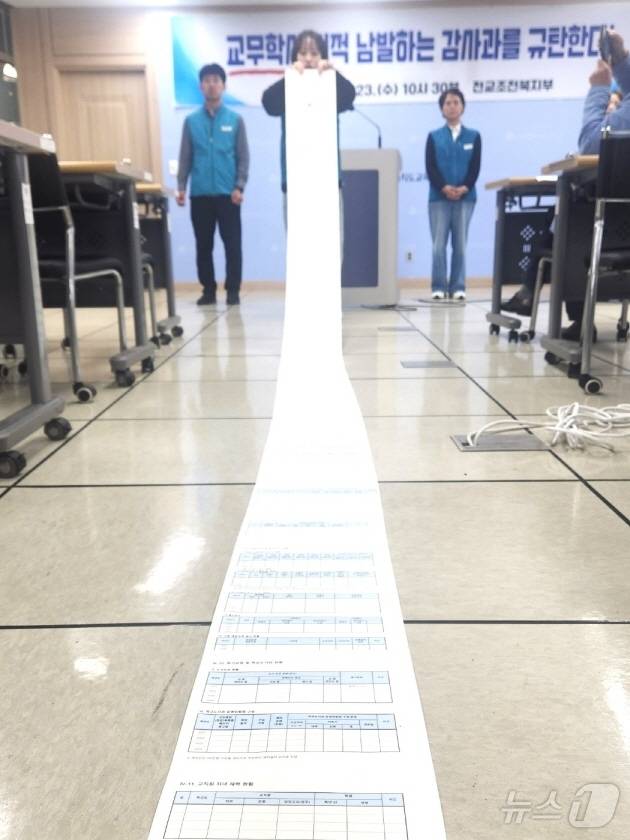 전교조 전북지부가 23일 전북교육청에서 기자회견을 갖고 교사업무 과중 등 '교무·학사 감사'의 문제점에 대해 지적하고 있다. 사진은 감사요구 자료를 길게 펼친 모습./뉴스1 임충식기