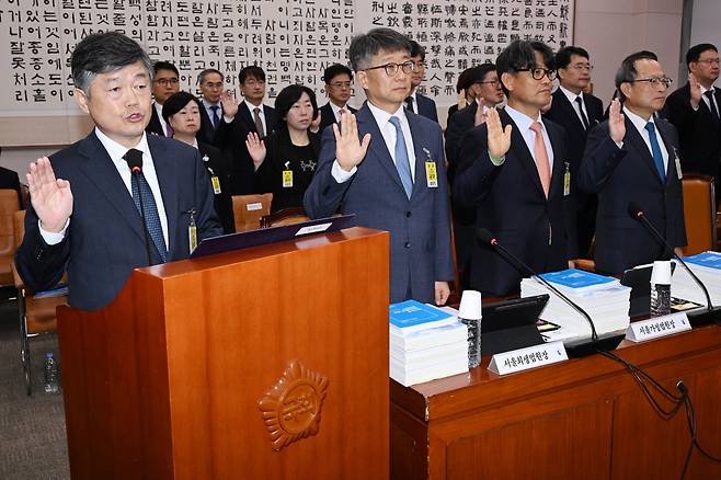 윤준(왼쪽) 서울고등법원장을 비롯한 법원 관계자들이 22일 국회 법제사법위원회 국정 감사에서 증인 선서를 하고 있다. 이날 법사위 국감에서 여야 의원들은 이재명 더불어민주당 대표가 받고 있는 여러 재판을 두고 공방을 벌였다. /이덕훈 기자