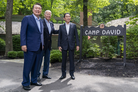 U.S. President Joe Biden, center, greets South Korean President Yoon Suk Yeol, left, and Japanese Prime Minister Fumio Kishida, right, at Camp David in Maryland on Aug. 18, 2023 [AP/YONHAP]