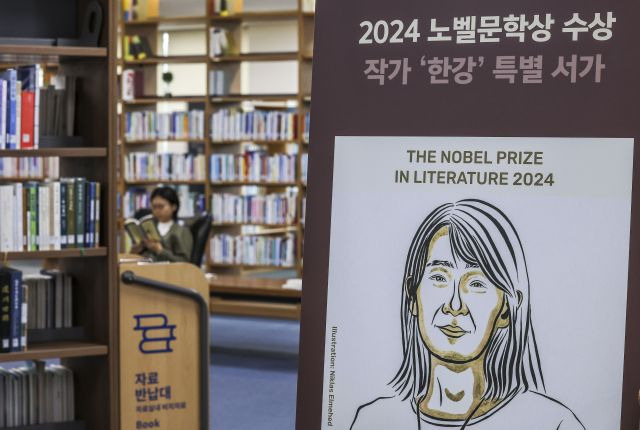 지난 21일 서울 서초구 국립중앙도서관 본관 문학실에 마련된 한강 특별서가를 찾은 시민이 한강 작가의 책을 보고 있다. 뉴시스