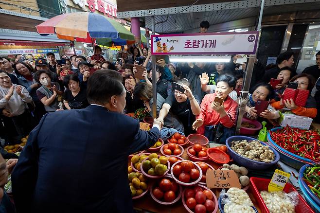 윤석열 대통령이 지난 22일 부산 동구 초량시장을 방문해 시민과 악수하고 있다. 대통령실은 이날 “여러분들을 더 잘 살게 해드려야겠다는 마음이 든다”며 “더 열심히 일하겠다”고 했다. /대통령실