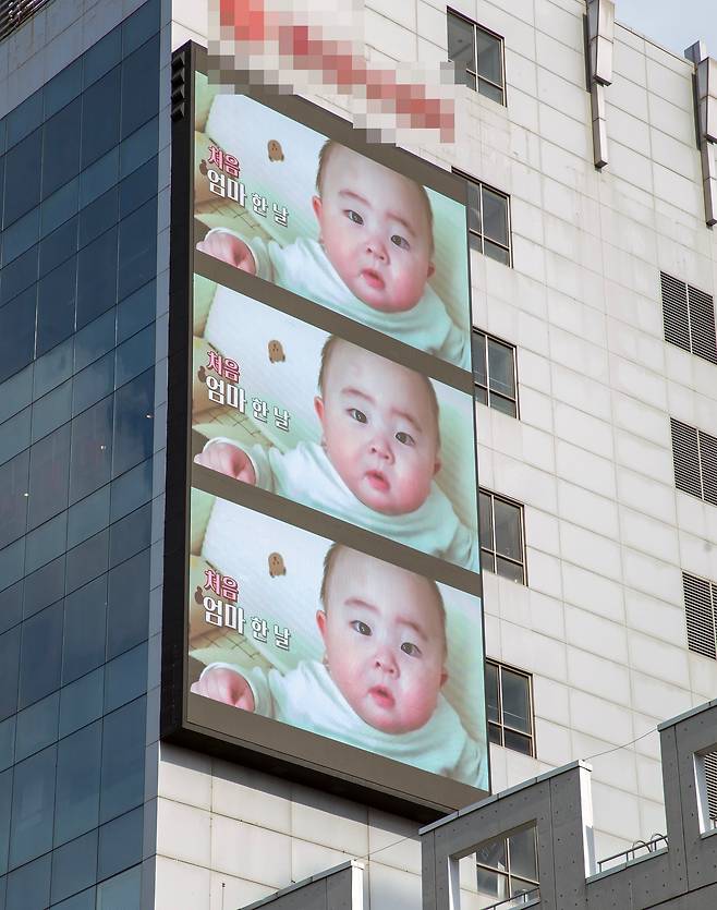 9일 서울 홍대앞역 한 극장 외벽에 걸린 세로화면 광고판, 외부에서 가로로 촬영된 홍보영상을 세 개로 겹쳐서 세로 화면에 보여주고 있다.  /조인원 기자