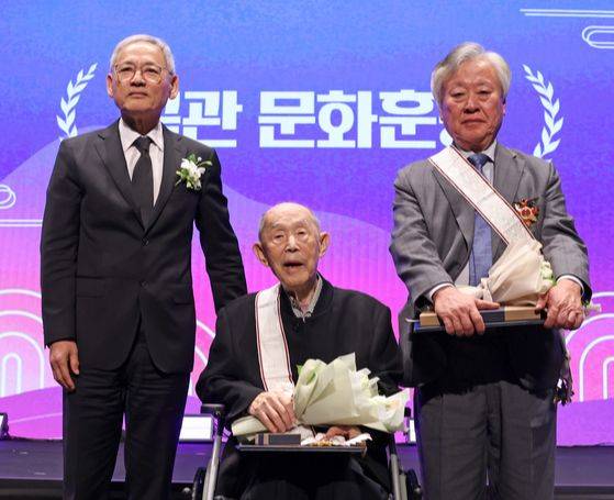작가 이문열씨(오른쪽)와 원로 연극 연출가 김정옥씨(가운데)가 25일 문화예술 분야 최고 공로상인 금관문화훈장을 받았다. 왼쪽은 문화체육관광부 유인촌 장관. [사진 문화체육관광부]