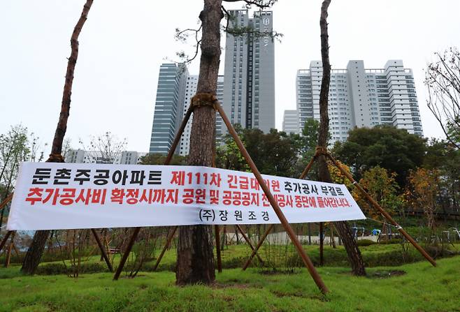 공사비 분쟁이 불거졌던 서울 강동구 둔촌주공 재건축(단지명 '올림픽파크포레온') 사업 공사가 조합과 시공사의 210억 증액 협상 끝에 재개됐다. 사진은 지난 22일 서울 강동구 올림픽파크포레온 단지에 공사중단을 알리는 현수막이 게시된 모습.  /사진=뉴시스