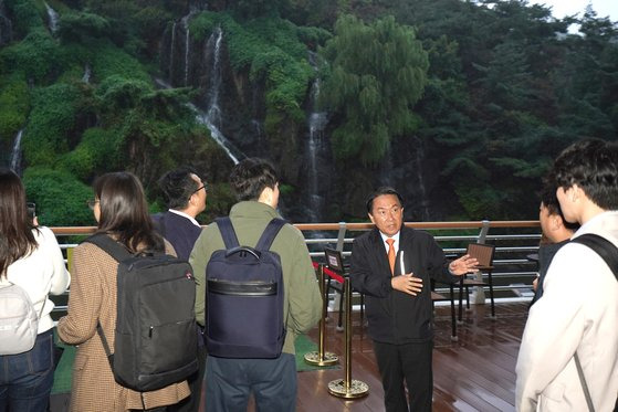 카페 폭포와 홍제 폭포에 대해 설명 중인 이성헌 서대문 구청장(오른쪽 셋째)의 모습. 폭포 맞은 편에 카페가 들어서 있어 자연스레 경관을 즐길 수 있도록 했다. 사진 서대문구