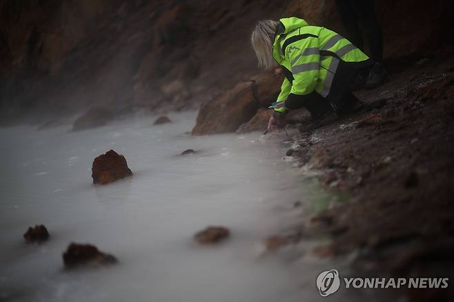 아이슬란드 아스캬 화산 분화구에서 온도를 측정하는 현지 화산학자 [로이터 연합뉴스 자료사진. 재판매 및 DB 금지]