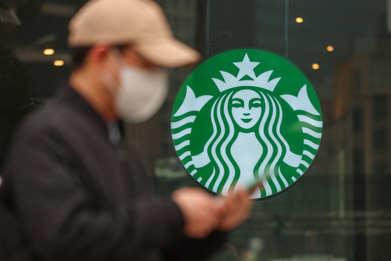 A pedestrian walks by a Starbucks store in Seoul in March. [YONHAP]