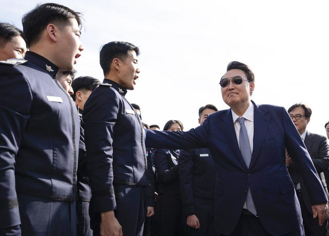 윤석열 대통령이 지난 25일 서울 용산 대통령실 앞에서 공군사관학교 4학년 생도들을 만나 격려하고 있다. 졸업을 앞둔 생도들은 이날 국가안보실 등을 견학했는데, 윤 대통령의 방문은 예고 없이 이뤄졌다.  대통령실 제공