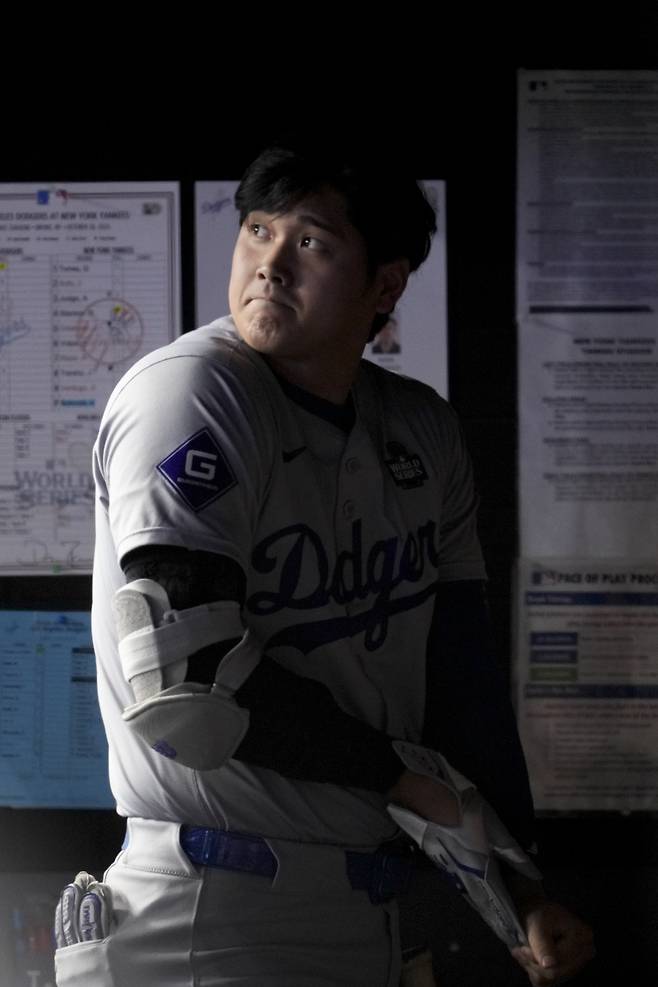 LA 다저스 오타니 쇼헤이가 29일(한국시각) 양키스타디움에서 열린 뉴욕 양키스와의 월드시리즈 3차전에서 4회 배팅 장갑을 챙기며 경기장을 응시하고 있다. AP연합뉴스