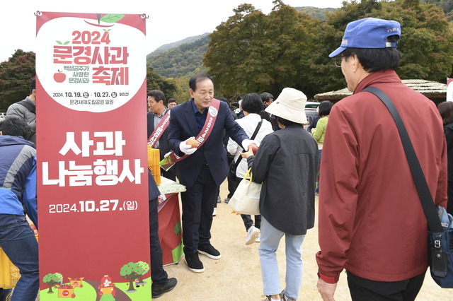 신현국 문경시장에 축제장을 찾은 관람객들에게 사과를 나눠 주고 있다.   문경시 제공