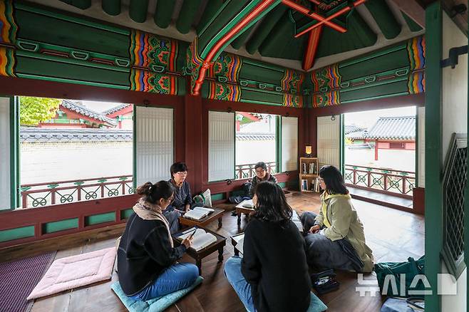 [서울=뉴시스] 김선웅 기자 = 29일 서울 종로구 창덕궁 궐내각사 권역 검서청에서 독서모임 회원들이 독서·토론 활동을 하고 있다. 국가유산청 궁능유적본부 창덕궁관리소는 29일부터 11월 3일까지 매일 창덕궁 궐내각사 권역에 위치한 규장각과 검서청 공간을 독서 관련 활동 모임 또는 단체들이 이용할 수 있도록 대여하는 '창덕궁 깊이보기, 궐내각사 규장각' 프로그램을 운영한다. 규장각과 검서청은 평소 문화유산 관리를 위해 내부관람이 제한되지만 독서의 계절 가을을 맞아 토론, 시 낭독 등 독서 관련 활동을 할 수 있도록 한시적으로 사전 신청 단체에 한해 내부가 공개된다. 2024.10.29. mangusta@newsis.com