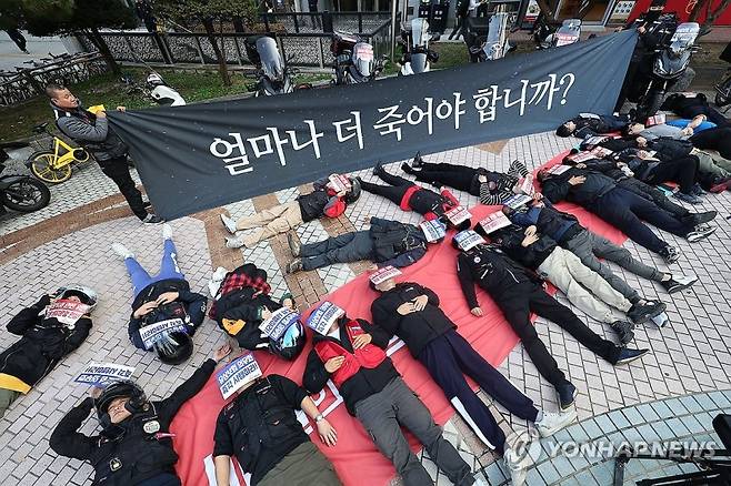 30일 오후 서울 송파구 우아한형제들 본사 앞에서 공공운수노조 라이더유니온 조합원들이 기본 배달운임 인상과 배달 기사의 요구가 반영된 배달앱 상생협의체 상생안을 촉구하며 '다잉 퍼포먼스'를 하고 있다.[연합]