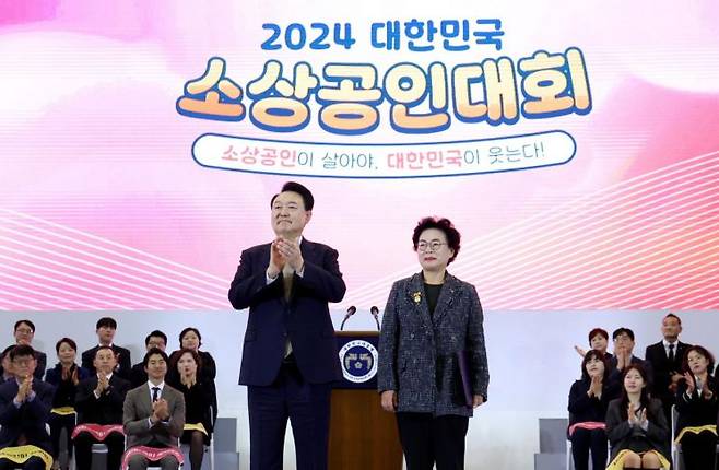 윤석열 대통령이 31일 경기도 고양시 킨텍스에서 열린 '2024 대한민국 소상공인대회 개막식'에서 라복임플로체 라복임 대표에게 대통령 표창을 수여한 뒤 박수치고 있다. [이미지출처=연합뉴스]