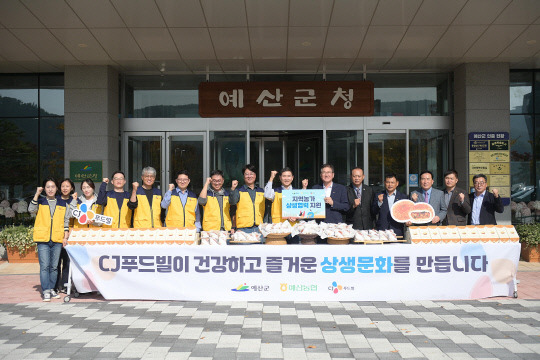 CJ푸드빌 임직원들이 예산군에 물품을 전달한 후 기념촬영하고 있다.사진=예산군 제공