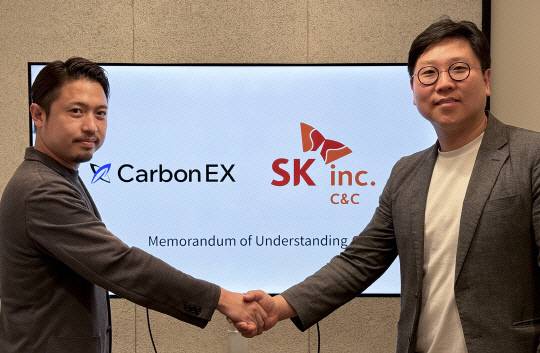 SK C&C는 일본 탄소 크레딧 거래소 운영사 '카본EX'와 손잡고 아시아 자발적 탄소배출권 시장 확장에도 나섰다. 지난 6월 MOU 체결식에서 타카유키 카게야마(왼쪽) 카본EX COO와 박성태 SK C&C 카본사업개발팀장이 기념촬영하고 있다. SK C&C 제공