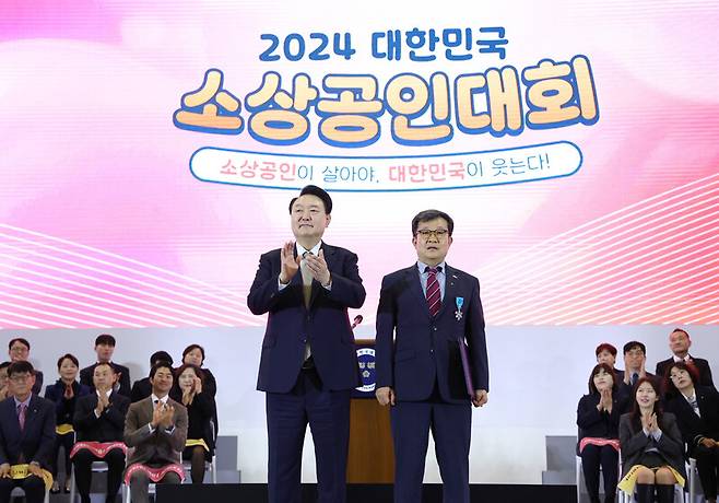 윤석열 대통령이 31일 경기도 고양시 킨텍스에서 열린 ‘2024 대한민국 소상공인대회’ 개막식에서 제주특별자치도 소상공인연합회 박인철 회장에게 산업포장을 수여한 뒤 박수치고 있다. 연합뉴스