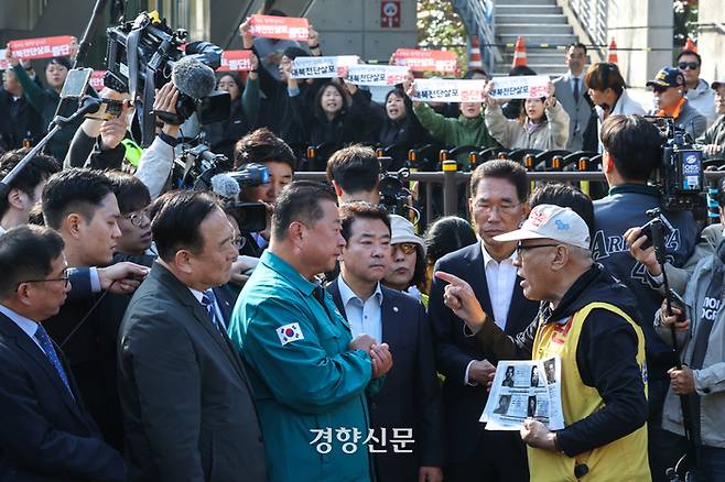 최성룡 납북자피해가족연합회 대표가 31일 경기도 파주시 임진각 6·25전쟁 납북자기념관 앞에서 대북 전단 살포를 시도하던 중 김경일 파주시장, 민주당 의원들과 대화하고 있다. 뒤로는 시민단체가 대북 전단 살포를 규탄하는 손팻말을 들고 있다.  성동훈 기자