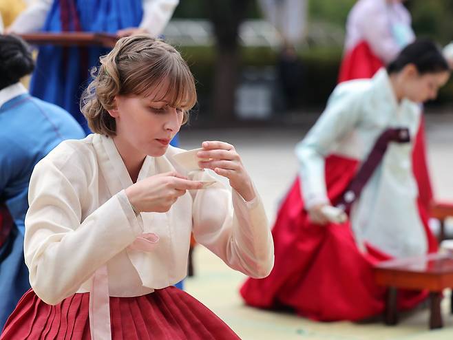 A foreign tourist participates in a traditional coming-of-age ceremony during the 2024 Hanbok Culture Week at the National Folk Museum of Korea in Jongno District, central Seoul, on Oct. 14. [NEWS1]