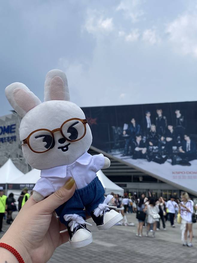 Claudia Vidal, a 27-year-old from Chile, takes a picture of her Stray Kids-themed Skzoo doll in front of the KSPO Dome in southern Seoul ahead of the boy band's concert in late August. [CLAUDIA VIDAL]