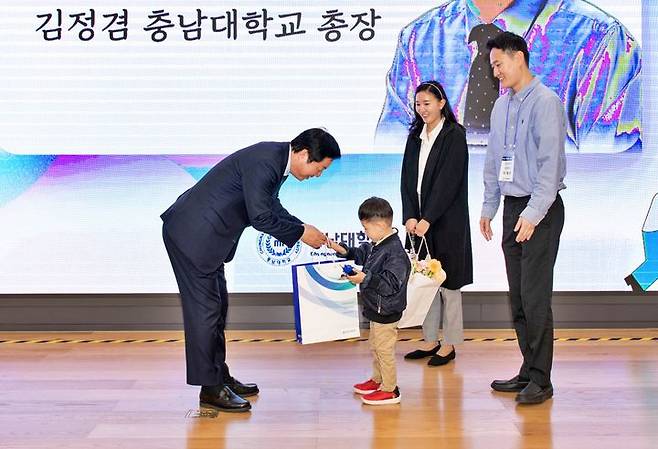 [대전=뉴시스] 30일 대전 유성구 충남대학교에서 열린 신임 교원 간담회에서 김정겸 총장이 신임 교원 자녀에게 대학에서 마련한 선물을 전달하고 있다. (사진=충남대 제공) 2024.10.31. photo@newsis.com   *재판매 및 DB 금지