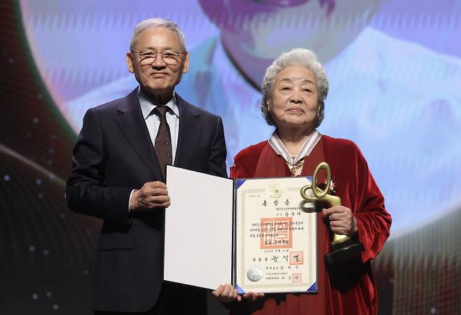 유인촌 문화체육관광부 장관이 31일 서울 중구 국립극장 해오름극장에서 열린 ‘2024 대한민국 대중문화예술상’ 시상식에서 배우 강부자에게 은관문화훈장을 전수한 뒤 기념촬영을 하고 있다.(사진=문체부 제공).