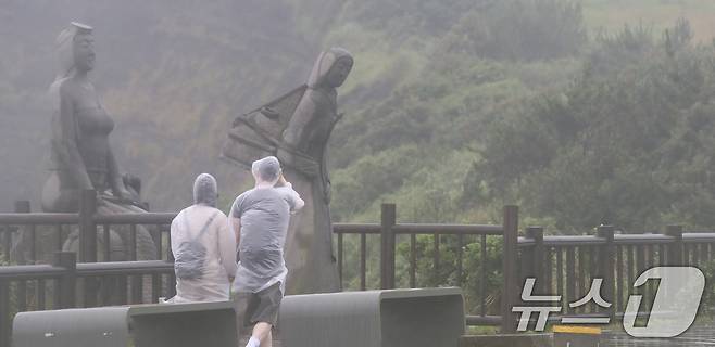 오전 서귀포시 대정읍 송악산 둘레길에서 관광객들이 우비를 입고 이동하고 있다. 2024.6.30/뉴스1 ⓒ News1 오현지 기자