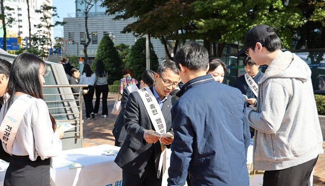 지난 달 31일 NH농협생명 임직원들이 서대문구역 인근에서 떡과 식혜를 시민들에게 나눠주고 있다. ⓒNH농협생명