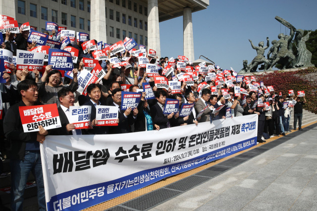 더불어민주당 을지로위원회와 전국가맹점주협의회, 민변, 참여연대 등이 지난달 17일 오후 서울 여의도 국회 본청 앞 계단에서 배달앱 수수료 인하 및 온라인플랫폼법 제정 촉구대회를 하고 있다. 뉴스1