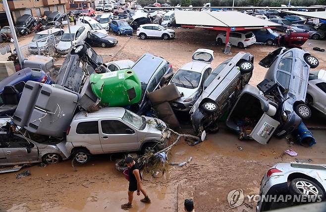 홍수에 휩쓸려 쌓인 차량 [AFP=연합뉴스]