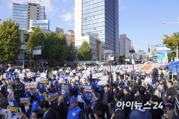 2일 서울역 인근에서 진행된 '김건희·윤석열 국정농단 규탄·특검촉구 국민행동의 날' 집회에 참여한 민주당 소속 국회의원·당원·시민들이 피켓을 머리 위로 드는 모습. [사진=라창현 기자]