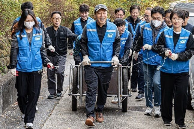 김문석 SBI저축은행 대표이사가 SBI희망나눔 봉사단원들과 함께 연탄을 배달하고 있다. ⓒ SBI저축은행