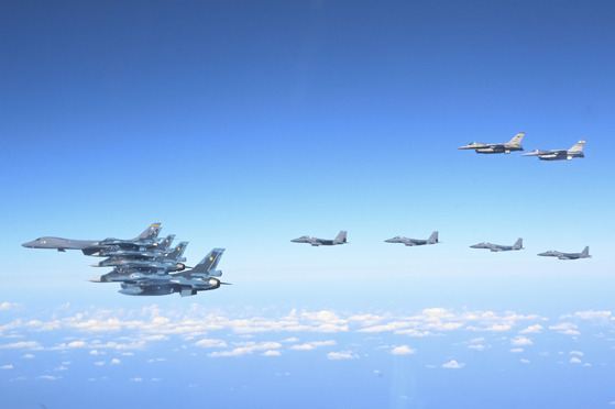 A U.S. B-1B heavy supersonic bomber, first from left, flies accompanied by F-15K jets from the South Korean Air Force, center, F-16 jets from the U.S. Air Force, top right, and F-2 jets from the Japan Air Self-Defense Force, lower left, over waters east of Jeju Island on Sunday. [U.S. AIR FORCE]