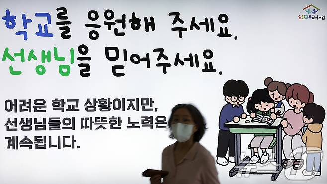 서이초 교사 순직 1주기(18일)를 앞둔 16일 서울 중구 봉래동 지하철 서울역에 실천교육교사모임이 모금을 통해 게시한 추모 광고 앞으로 시민이 지나고 있다. 2024.7.16/뉴스1 ⓒ News1 박정호 기자