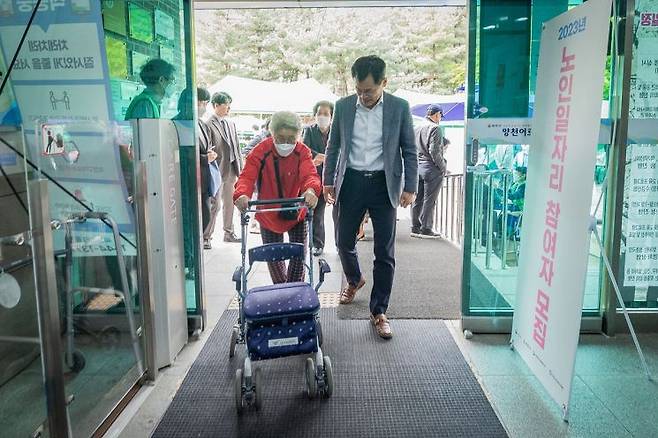 보행기 이용 어르신과 복지관에 들어서는 이기재 양천구청장. 양천구 제공.