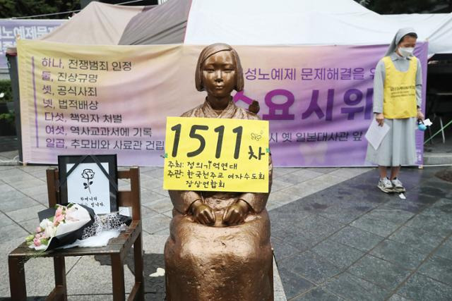 일본군 성노예제 문제해결을 위한 정기 수요집회가 열린 2021년 9월 29일 서울 종로구 옛 일본대사관 앞. 평화의 소녀상에서 참석자들이 같은 달 24일 별세한 일본군 위안부 피해자 할머니를 추모하고 있다. 연합뉴스