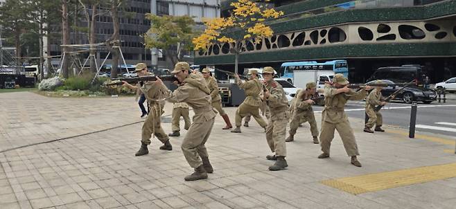 11월 14일 개봉 영화 ‘춘천대첩 72시간’ 홍보 이벤트로 배우들이 인민국 복장과 총기를 소지하고 전투대형으로 이동하는 깜짝 이벤트를 벌였다. (사진=나인픽처스 제공)