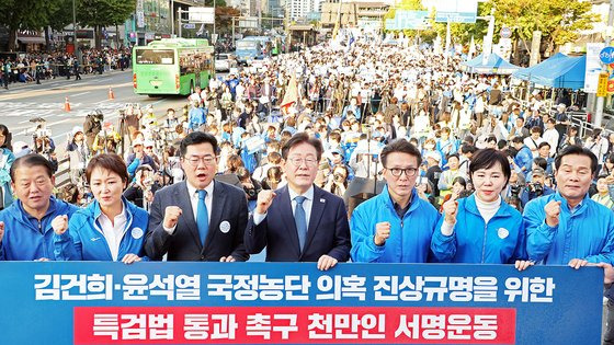 이재명 더불어민주당 대표가 2일 오후 서울 중구 서울역 인근에서 열린 ‘김건희 국정농단 범국민 규탄대회’에서 박찬대 원내대표를 비롯한 주요 참석자들과 함께 김건희?윤석열 국정농단 의혹 진상규명을 위한 특검법 통과 촉구 천만인 서명운동판에 서명한 뒤 기념촬영하고 있다. (공동취재) 2024.11.2/뉴스1